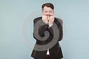 Worry business man bites his nails with excitement