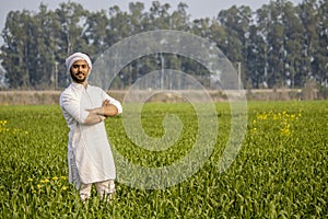 worry less indian farmer standing hand folded in his healthy wheat field