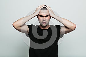 Worrying man posing at studio with arm on head