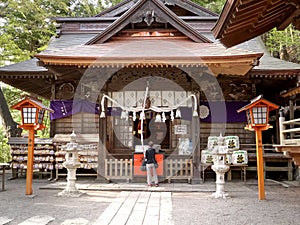 Worshiper rings a bell at arakura sengen shrine in japan