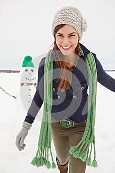 The worst thing about winter - photobombing snowmen. a gorgeous young woman walking passed a snowman.