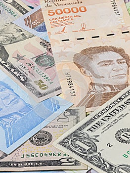 The almost worthless Venezuelan money on a bunch between the strong US dollars. Bolivares or Bolivar, the currency of Venezuela.