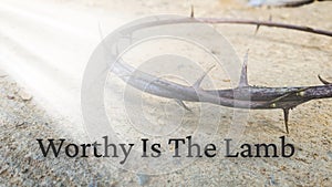 Worthy Is The Lamb text with shinning light on crown of thorns background. Easter and Christianity concept