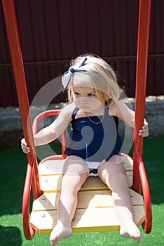 Would you wear this hairstyle. Small child wear headband hairstyle. Small girl on swing. Girl child with blond hair