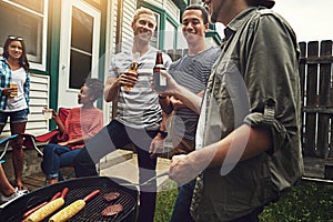 It wouldnt be a bbq without your best mates. a group of friends having a barbecue in the yard.