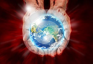 Wounded hands of Christ holding the earth