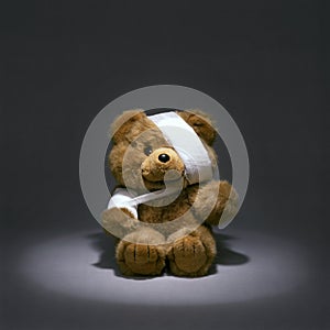 Wounded toy teddy bear with bandages and sling