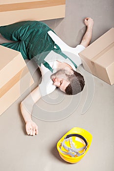 Wounded warehouse worker lying on the floor photo
