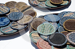 Woven drink coasters in sunlight on bar table