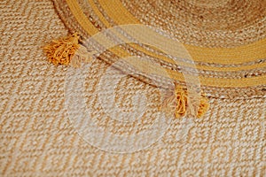 Woven mat with yellow tassels.