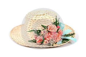 Woven woman hat with artificial rose flowers and leaves with blue ribbon isolated on white background