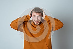 Wow amazing. Happy and excited bearded modern young man smiling astonished, checking out something awesome and cool