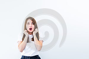 Wow. Beautiful female portrait looking at camera isolated on white backgroud. Young emotional surprised, shocked woman standing wi