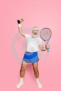 Wow Competetive best cool healthy modern successful active grandpa with big tennis equipment and reward raised in hand