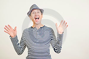 Wow! Excited man with open mouth over white background. Handsome guy in retro fashion hat and striped shirt. Emotion, gesturing