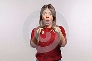 Wow, hey you! Portrait of amazed shocked brunette woman in shaggy sweater pointing finger to camera, isolated