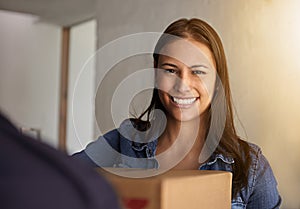 Wow I wasnt expecting my package so soon. a young woman receiving a delivery at home.