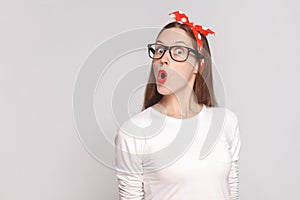 wow its unbelievable, portrait of beautiful emotional young woman in white t-shirt with freckles, black glasses, red lips and