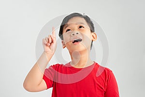 Wow look, advertise here! Portrait of amazed cute little boy with curly hair pointing to empty place on background