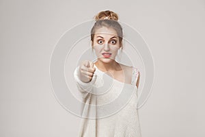 Wow, no way! Surprised woman pointing finger at camera and shoc