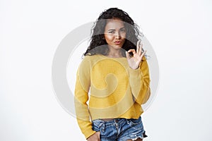 Wow really not bad, good choice. Impressed good-looking modern african-american 20s woman in yellow sweater, nod