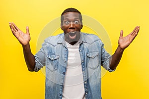 Wow, it`s unbelievable! Portrait of bewildered shocked man raising arms in amazement. indoor studio shot isolated on yellow