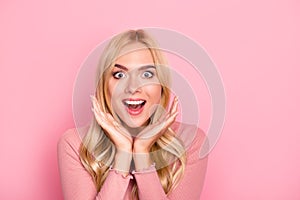 Wow, sale. Close up portrait of young pretty woman with long blond hair looking exited holding her mouth open, hands near cheeks,