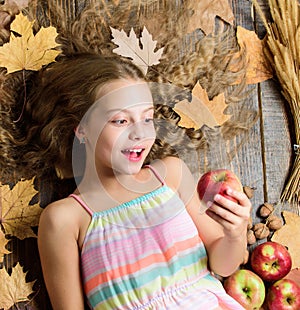 Wow. Small girl likes the taste of apple fruits. Cute girl child with ripe autumn crops. Organic and natural food for