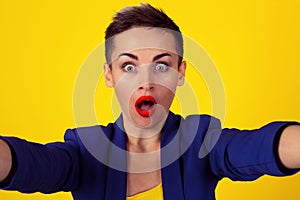 Wow. Stunned, selfie shot. Closeup woman short hair girl looking stunned frustration amazement on face while doing a selfie on