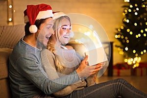 Wow! Surprised Christmas couple opening magical gift box