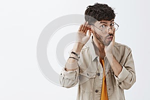 Wow tell me all dirty details of recent rumor. Intrigued good-looking stylish office worker in glasses and trendy beige