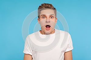 Wow, unbelievable! Portrait of astonished man in casual white t-shirt looking at camera with mouth open in amazement