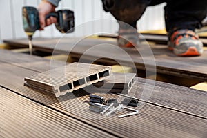 Wpc terrace construction - worker installing wood plastic composite decking boards