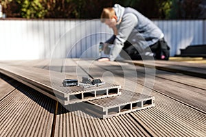 Wpc terrace construction - worker installing wood plastic composite decking boards