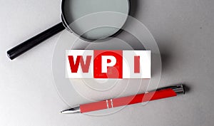 WPI word on wooden cubes with pen and magnifier