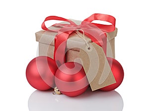 Wraped gift box with red bow, christmas balls and tag
