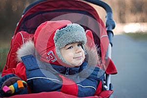 Wrapped baby boy in red stroller