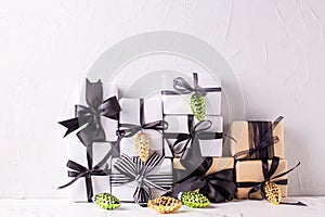Wrapped boxes with presents  and golden and green decorative cones against white textured background.