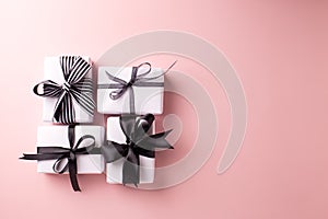 Wrapped boxes with presents on pastel pink background.