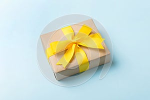 Wrapped christmas or other holiday handmade present in craft paper with colored ribbon. Present box, decoration of gift