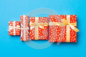 Wrapped Christmas or other holiday handmade present in paper with gold ribbon on blue background. Present box, decoration of gift