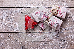 Wrapped christmas presents, key and decorative fur tree on aged