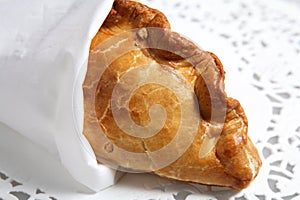 Wrapped cornish pasty meat pie on doiley photo