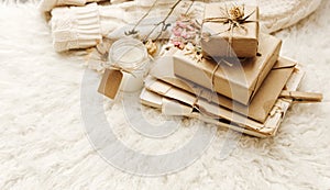 Wrapped craft gift boxes with dry flowers over fur background.