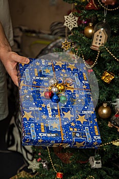 Wrapped gifts under the festively decorated Christmas tree in the hands. Life style