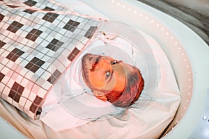 Wrapped man lying in the spa capsule