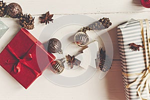 Wrapped present boxes with ornaments pine cones anise on white w