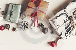 Wrapped present boxes with ornaments pine cones anise on white w