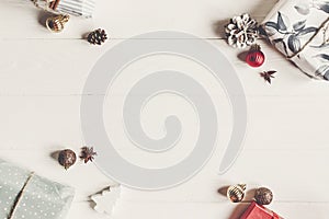 Wrapped present boxes with ornaments on white wooden background