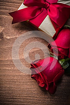 Wrapped present with red ribbon natural roses